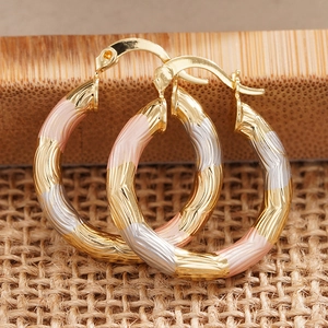 Three-tone hoop earrings in gold, silver, and rose gold with textured wavy metal design