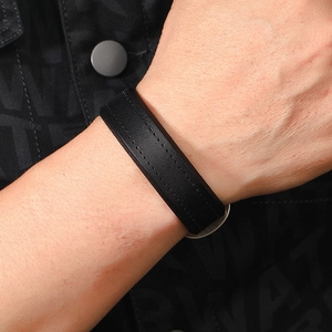 Close-up of black leather men's punk bracelet with double stitching detail on wrist