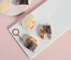 Vue détaillée de breloques réalistes en chair de poisson avec texture et porte-clés doré