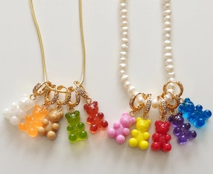Detailed view of colorful gummy bear necklaces with gold chains and pearl accents
