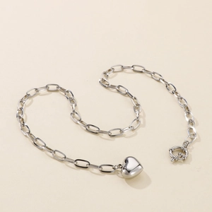 Detailed view of silver paperclip chain necklace with a 3D heart pendant and OT clasp