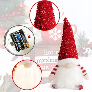 Detail view of glowing Christmas gnome showing battery compartment and sequin fabric texture