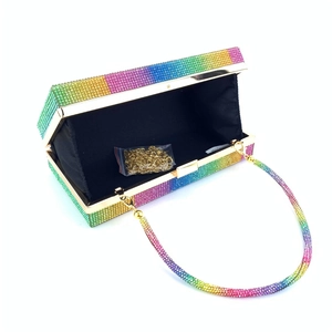 Detail of open rainbow rhinestone clutch bag with gold chain strap and black lining