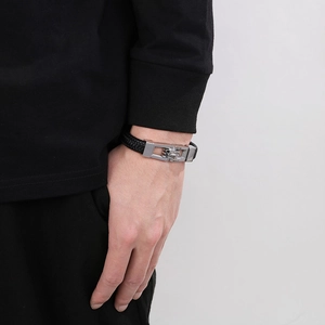 Close-up of black braided leather bracelet with silver metal clasp on male wrist