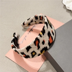 Korean style plush leopard print knitted headband with handmade label on a minimal pink setup