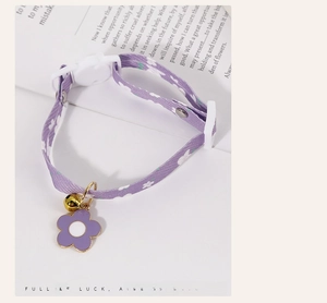 Detail of adjustable purple floral pet collar with sunflower pendant and golden bell charm