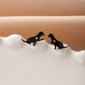 Gros plan de boucles d'oreilles chien noires avec cœur sur un plateau nuage blanc