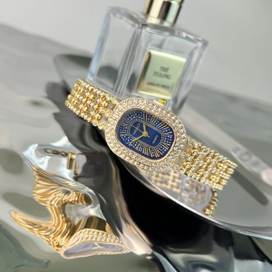 Detail of elegant gold-tone oval watch with blue dial and sparkling rhinestones