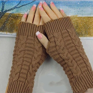 Detail of brown cable-knit fingerless gloves with elegant textured pattern on wrist