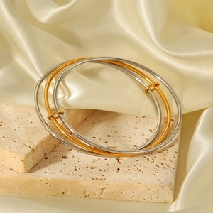 Minimalist adjustable stainless steel bangles set in gold and silver on silk background