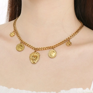 Gold Cuban chain necklace with lion head, coin and clover charms worn by a model