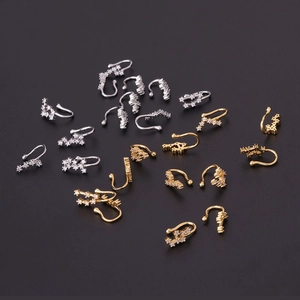 Gold and silver zodiac nose rings with inlaid zircons on a professional black background