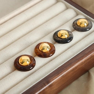 Vintage geometric resin and brass hoop earrings with tortoise shell pattern in a display tray