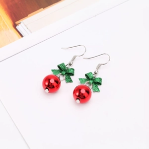 Christmas earrings featuring red glossy beads and sparkling green glitter bow accents