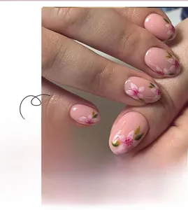 Detailed view of translucent pink press-on nails with delicate floral patterns
