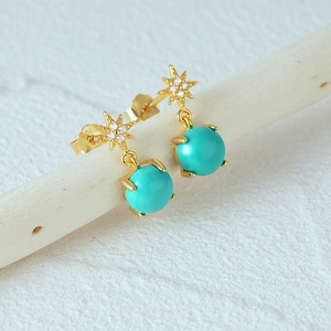Macro detail of S925 silver turquoise star earrings with gold finish and zircon stones