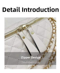 Detail view of white quilted crossbody bag with golden metal zippers and chain strap