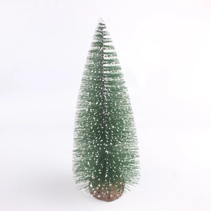 Detail of a mini green Christmas tree with white snow flocking and a wood base