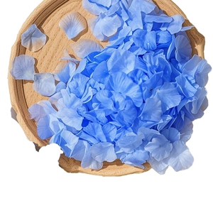 Artificial blue rose petals in a round wooden tray for wedding decoration and romance