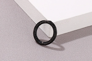 Detailaufnahme eines schwarzen Titanstahlrings mit stilvollem Rautenmuster-Gitterdesign