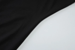 Detailed macro view of the premium black knit fabric texture on the sleeveless dress