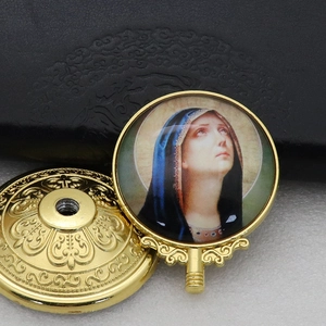 Detailed view of a vintage gold metal ornament featuring a Virgin Mary religious icon