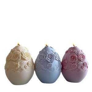 Lot de trois bougies en forme d'œuf avec relief de roses en beige, bleu et violet