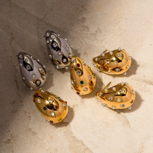 Close-up of teardrop earrings with 18K gold finish, inset pearls, and colorful crystals
