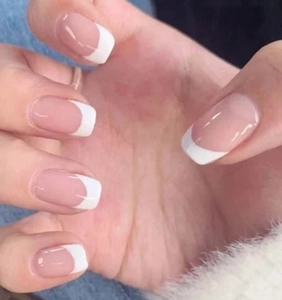 Detailed view of classic French style press-on nails with pink base and white tips