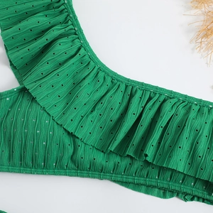 Macro detail of green ruffled bikini fabric with pleated texture and eyelet embroidery