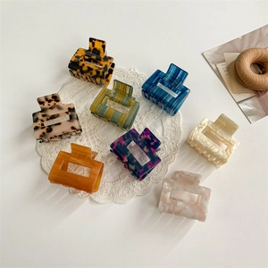 Detailed overhead view of eight acetate hollow square hair claws in assorted colors