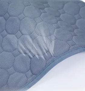 Close-up of gray-blue quilted dog pee pad with hexagonal honeycomb stitching pattern