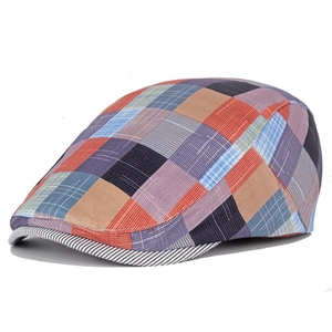 Detail of colorful plaid beret featuring multi-color checkered fabric and striped brim edge