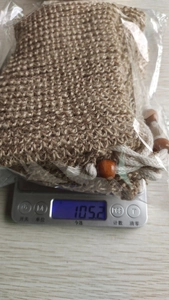 Detailed view of natural jute soap bag on digital scale showing weight of 105.2g