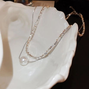 Double-layer silver necklace with white pearl pendant inside a decorative white shell