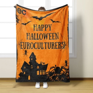 Halloween flannel blanket with castle and bat prints displayed by a standing model