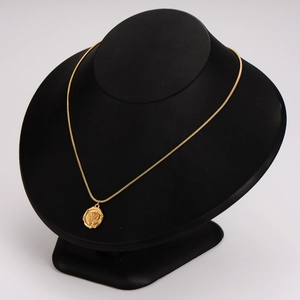 Vintage rose pendant necklace in gold finish displayed on a black jewelry stand