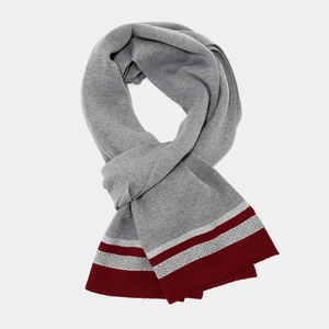 Detailed close-up of grey knit scarf with red and white stripes and herringbone pattern