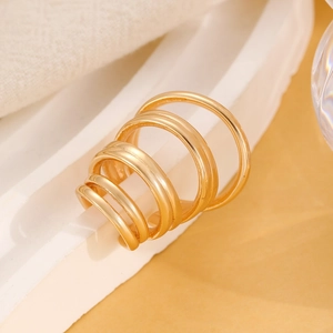 Detailed close-up of golden multi-layered geometric ear cuff with polished finish