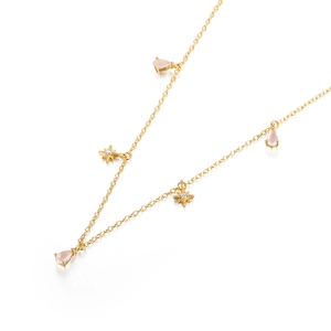 Detail of S925 silver gold-plated necklace with pink teardrop stones and star charms
