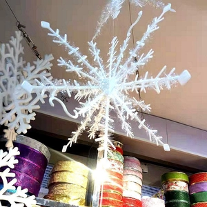Close-up of white glittery snowflake ornaments hanging for Christmas tree decoration