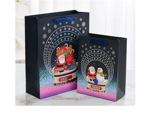 Detail of blue Christmas gift bags with gold foil patterns and satin handles