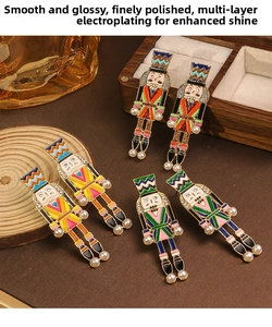Detailed view of nutcracker soldier drop earrings in three colorful enamel finishes