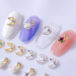 Celestial nail art charms with gold moon, stars and white roses on manicured nails