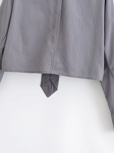 Close-up of gray cotton cropped shirt featuring stitched hem and pointed tie-up details