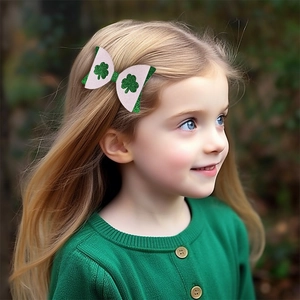 Glitter bow hair clip with shamrock pattern on a girl for St. Patrick's Day celebration