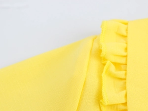 Macro shot of yellow fabric texture with delicate ruffled trim and pleated edge detail