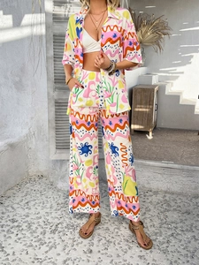 Detail view of colorful geometric patterns on bohemian vacation shirt and wide-leg trousers