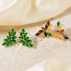 Elegant gold leaf studs with vibrant green and colorful crystal gemstones on stone base