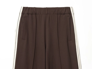Detail of dark brown track pants with elastic waist and contrast side stripe detail